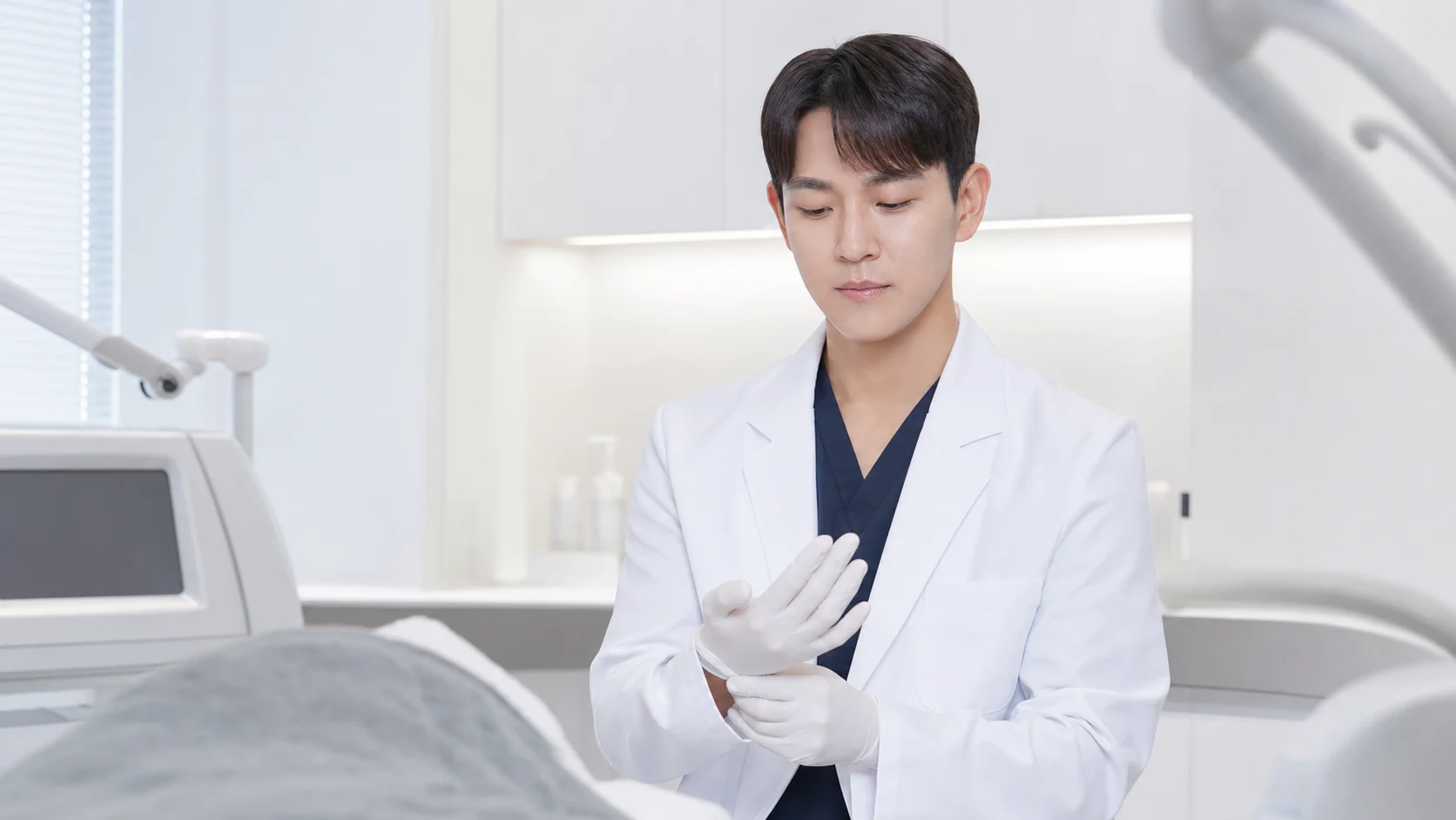 권형일 피부과 전문의가 시술실에서 장갑을 끼고 스킨부스터 주사 시술을 준비하는 모습